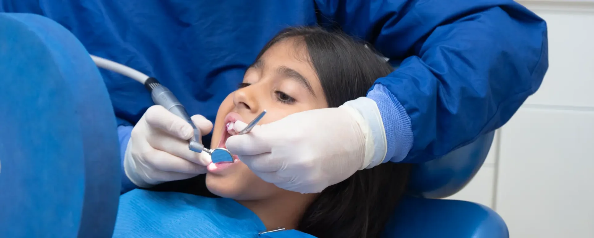 Dottoressa che esegue un controllo dei denti ad una bambina